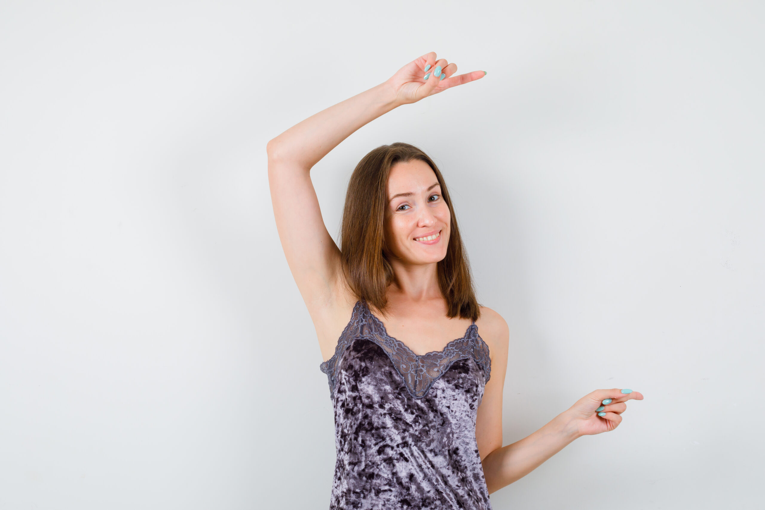 beautiful girl pointing right with index fingers in dress and looking cheery. front view.